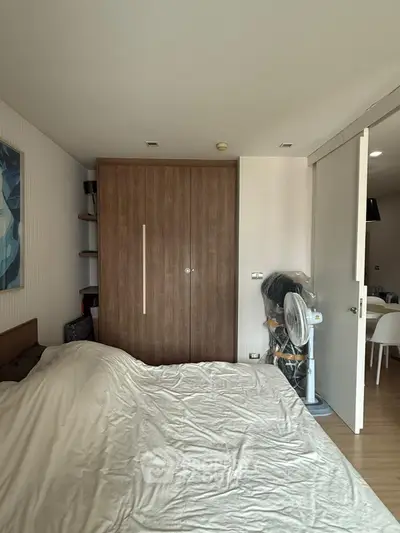 Cozy bedroom with wooden wardrobe and sliding door in modern apartment