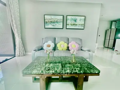 Charming living room with plush sofa, floral cushions, and elegant glass coffee table.