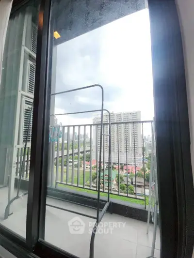 High-rise apartment balcony with city view and glass door