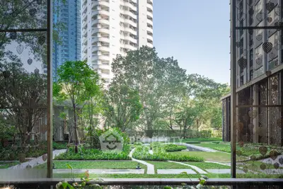 Luxurious garden view from modern apartment with lush greenery and elegant architecture.