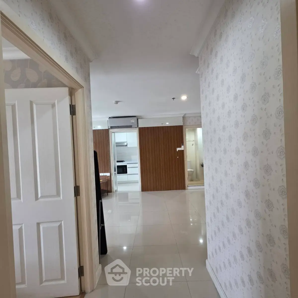 Spacious hallway leading to a modern kitchen with sleek appliances and elegant decor.