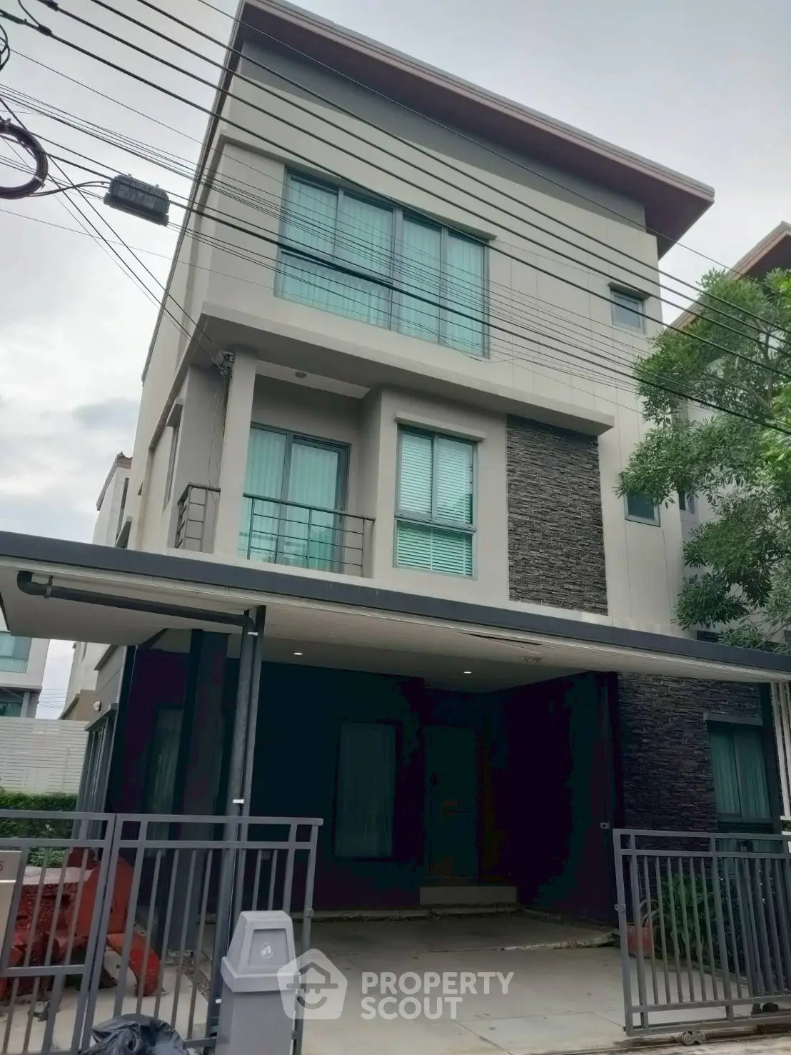 Modern three-story house with sleek design and gated entrance