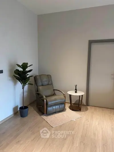 Minimalist interior with a cozy armchair and side table, perfect for relaxation.