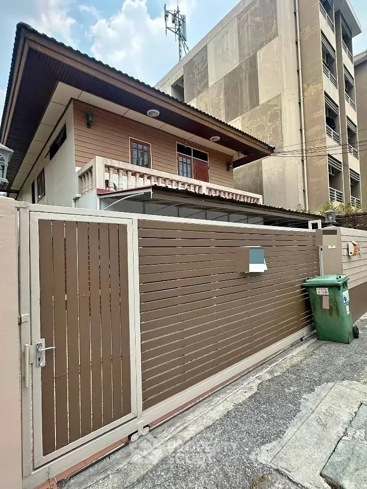 Charming two-story house with gated entrance in urban setting, perfect for modern living.