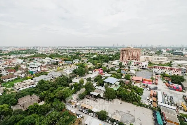 Stunning aerial view of urban landscape with lush greenery and city skyline in the distance.
