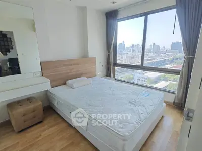 Spacious bedroom with large window offering stunning city views, featuring a comfortable bed and modern decor.