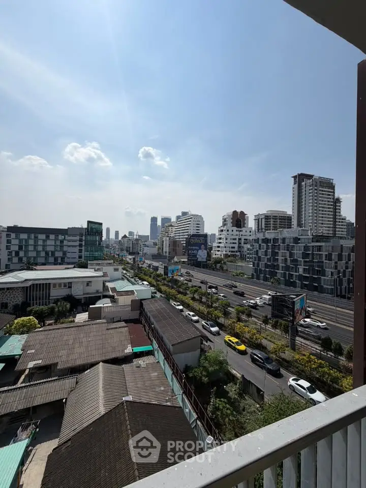 Stunning cityscape view from a high-rise balcony overlooking bustling urban streets and modern architecture.