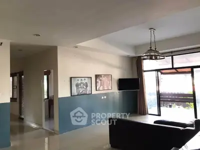 Spacious living room with large windows and modern decor in a stylish home.