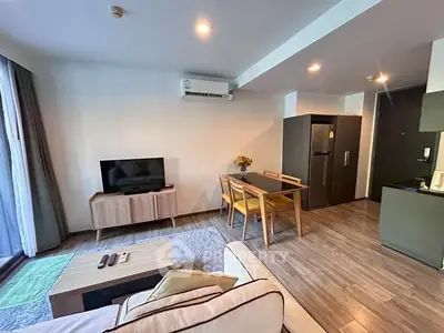 Modern living room with stylish furniture and open kitchen layout in a cozy apartment.