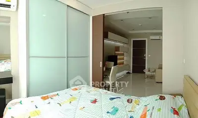 Modern bedroom with sliding doors and view into a stylish living area.