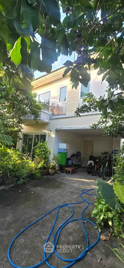 Charming two-story house with lush garden and spacious driveway, perfect for family living.