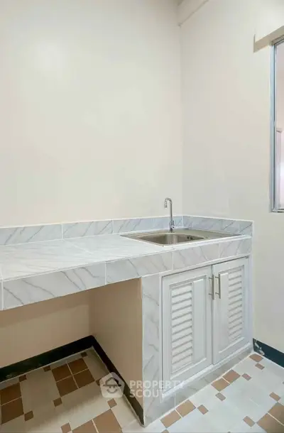 Modern kitchen with marble countertop and stainless steel sink