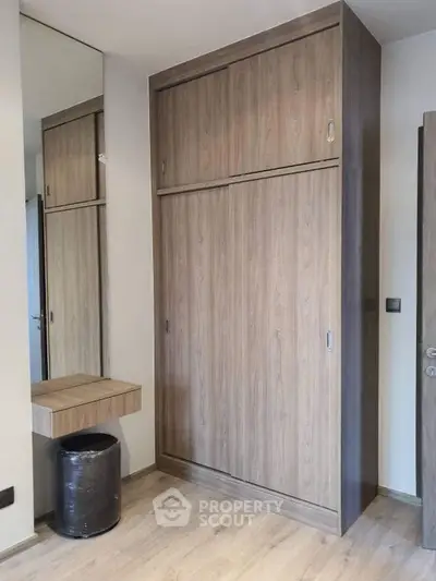Modern wooden wardrobe with sliding doors in a stylish bedroom setting.