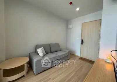 Cozy living room with modern sofa and wooden flooring in a stylish apartment.