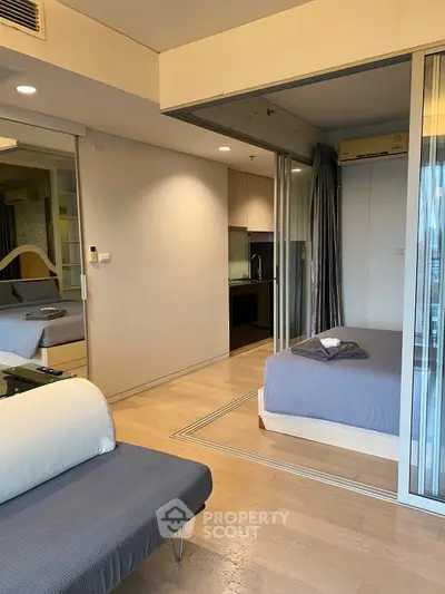 Modern studio apartment with open layout and sleek kitchen design, featuring cozy living area and stylish decor.