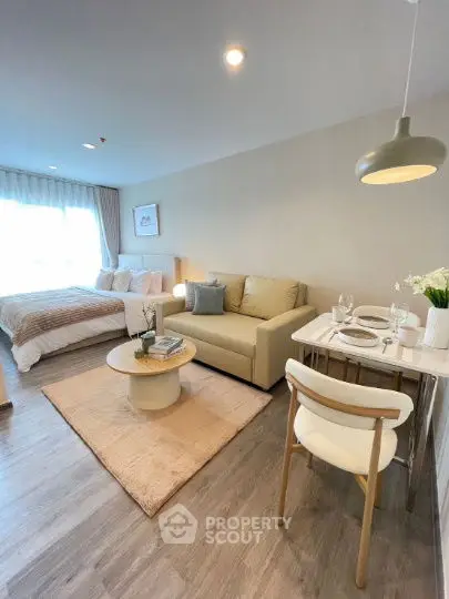 Modern studio apartment with cozy living area and dining space, featuring elegant decor and natural light.