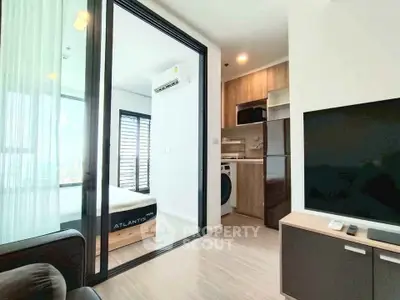 Modern apartment interior with open living area, bedroom, and kitchen featuring sleek appliances.