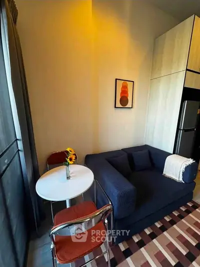 Cozy living room with modern decor, featuring a stylish sofa, dining table, and vibrant artwork.