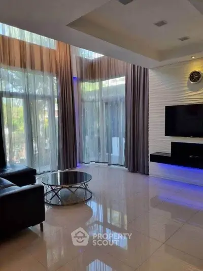 Luxurious living room with high ceilings, modern decor, and large windows for natural light.