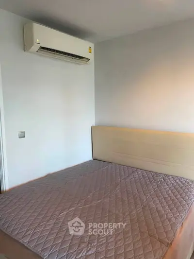Cozy bedroom with air conditioning and comfortable bed in modern apartment.