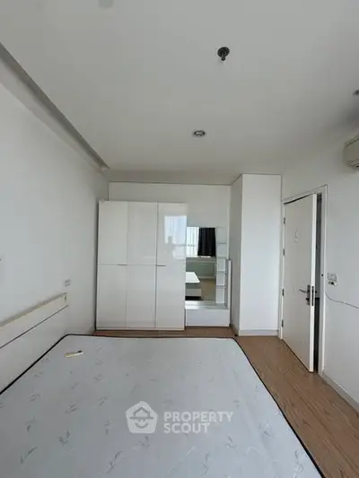 Spacious bedroom with modern wardrobe and minimalist design, perfect for comfortable living.