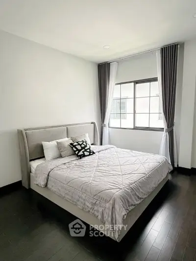 Modern bedroom with elegant decor and large window for natural light