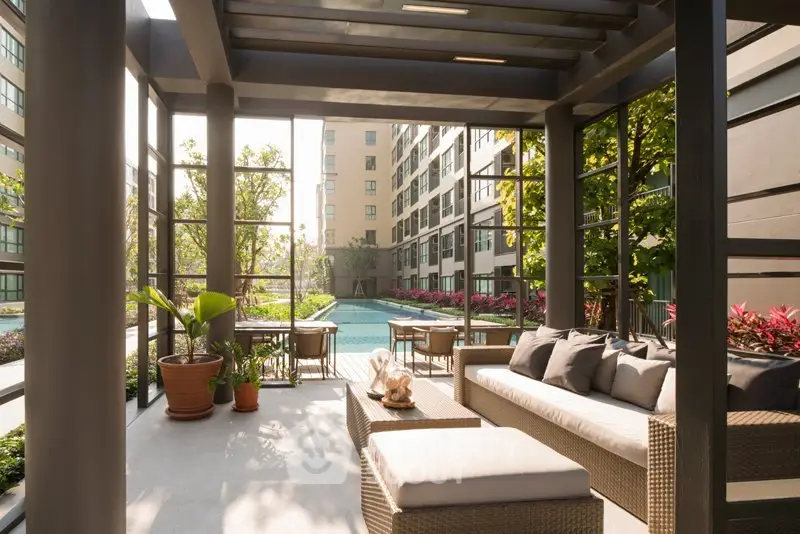 Luxurious outdoor seating area with pool view in modern apartment complex