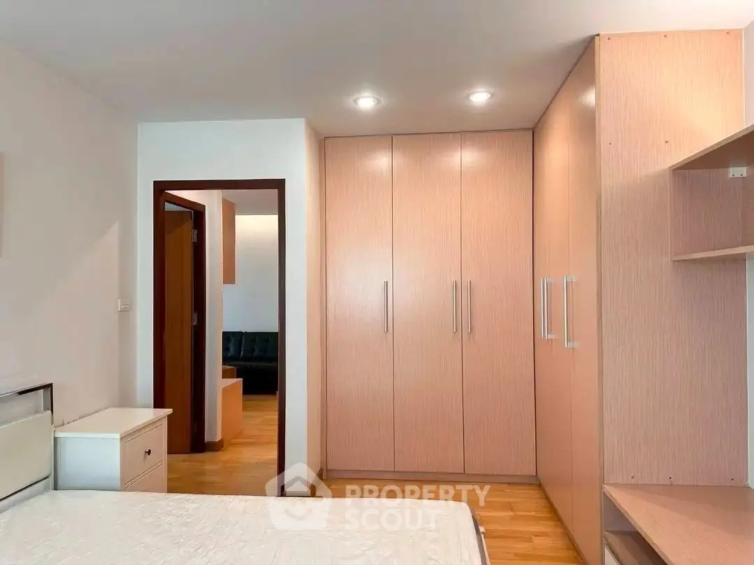 Spacious bedroom with built-in wardrobe and modern lighting, perfect for comfortable living.