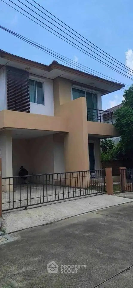 Modern two-story house with gated driveway and contemporary design.