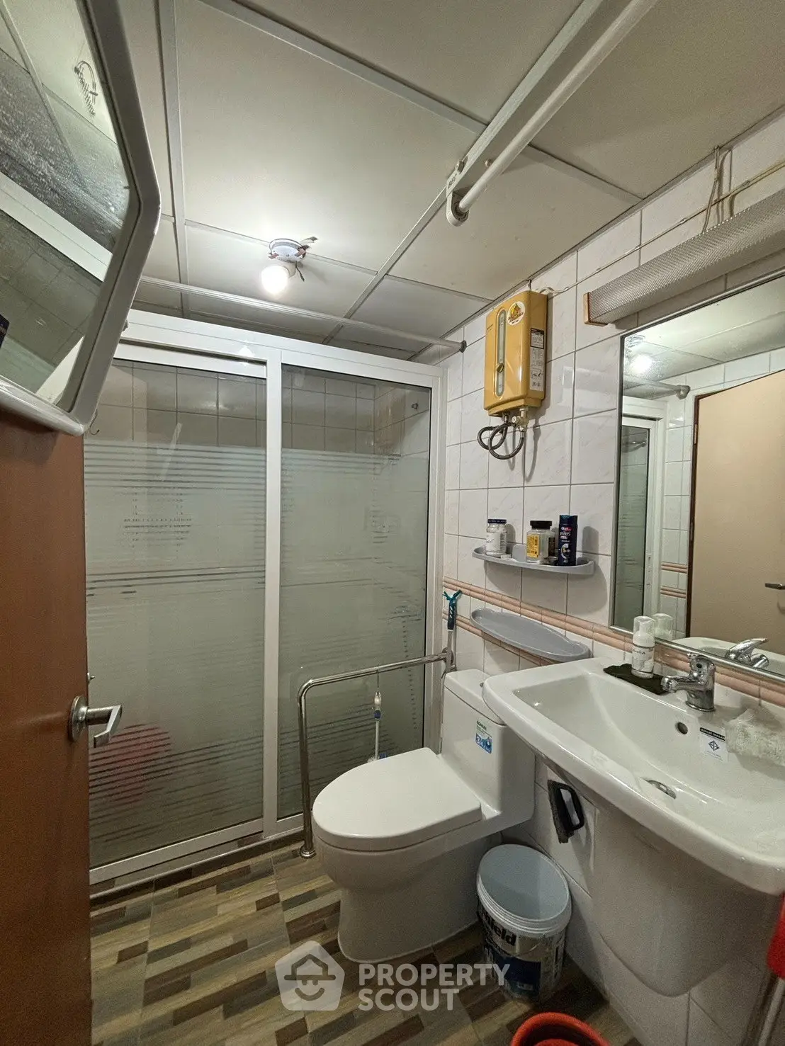 Compact bathroom with modern fixtures and walk-in shower in a cozy apartment.