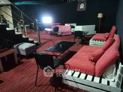 Stylish lounge area with modern pallet furniture and vibrant red cushions