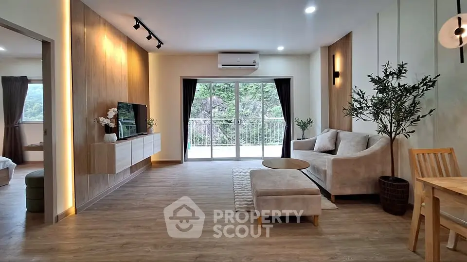 Spacious modern living room with elegant decor and large windows offering scenic views.