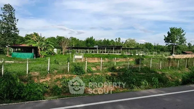 Expansive rural land with lush greenery and fencing, ideal for development or agriculture.