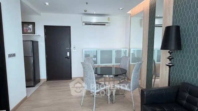 Modern living room with dining area, sleek furniture, and air conditioning in a stylish apartment.