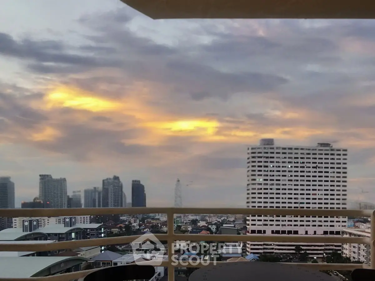 Stunning cityscape view from a high-rise balcony at sunset, showcasing urban skyline.