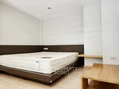 Spacious bedroom with modern design and wooden accents, perfect for relaxation.