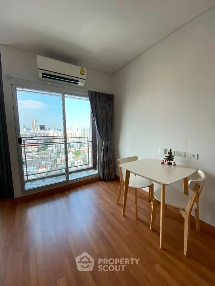 Bright dining area with city view, featuring wooden flooring and modern furniture.