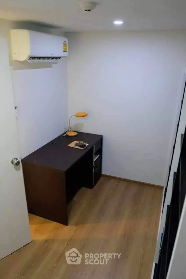 Compact study room with wooden flooring and modern desk setup