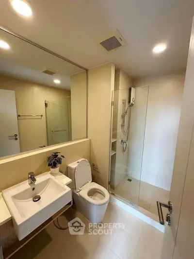 Modern bathroom with glass shower and sleek fixtures in a contemporary home.