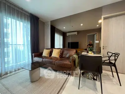 Modern living room with leather sofa, glass table, and mirrored wall in stylish apartment.