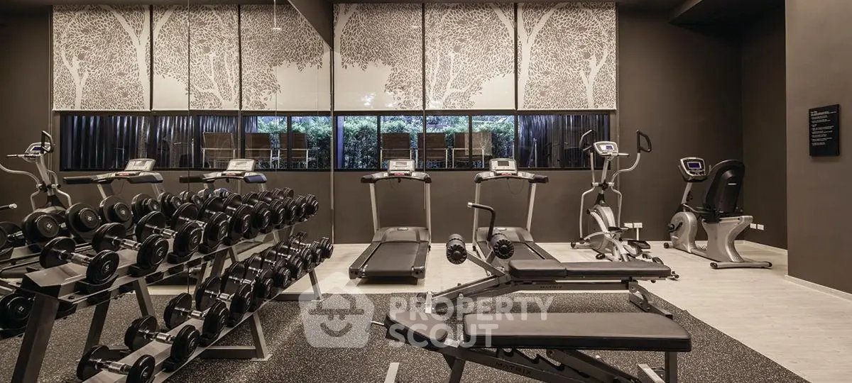 Modern gym with state-of-the-art equipment and serene decor in luxury residential building.