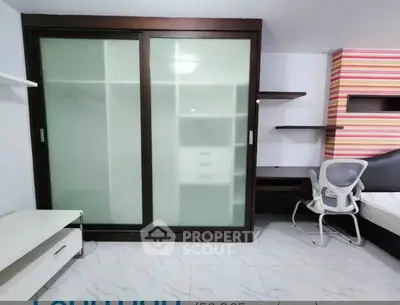 Modern bedroom with sliding closet doors and ergonomic chair