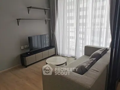 Modern living room with sleek furniture and natural light through large windows.