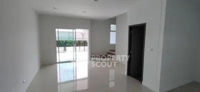 Spacious modern living room with glossy floors and sliding glass doors leading to a patio.