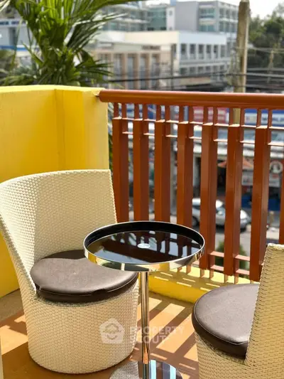 Charming balcony with cozy seating and vibrant city view, perfect for relaxation and enjoying the outdoors.