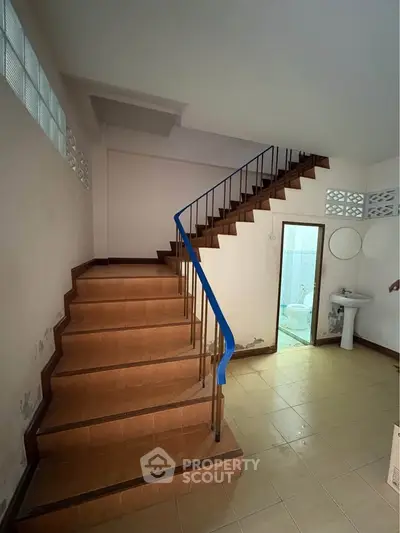 Spacious interior with staircase and bathroom access, ideal for renovation.