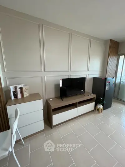 Modern living room with sleek TV stand, chest of drawers, and large window for natural light.