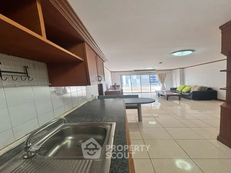 Spacious open-plan kitchen and living room with modern furnishings and balcony access.
