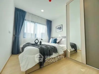 Modern bedroom with stylish decor and large mirrored wardrobe