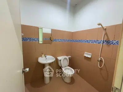 Modern bathroom with tiled walls and shower in a real estate property.